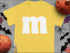 Yellow t-shirt with white M for Group Halloween T-Shirts Candy Character Theme