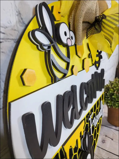 Hand painted round door hanger featuring a bee-themed welcome sign for front door decor