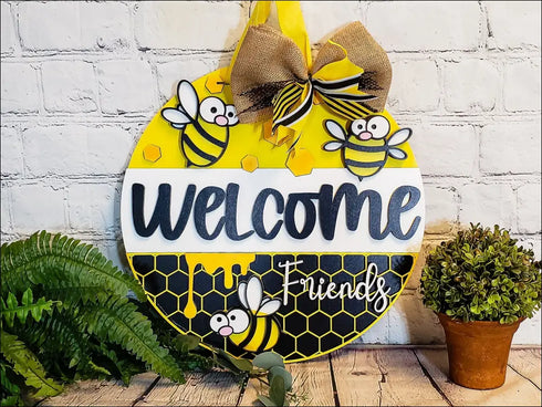 Hand painted round door hanger featuring a charming bee themed welcome sign