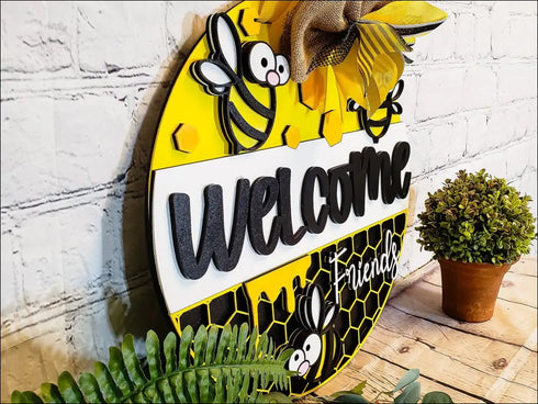 Hand painted round door hanger featuring a bee-themed welcome sign for front door decor