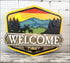Hand painted rustic welcome sign featuring a mountain scene for outdoor door decor