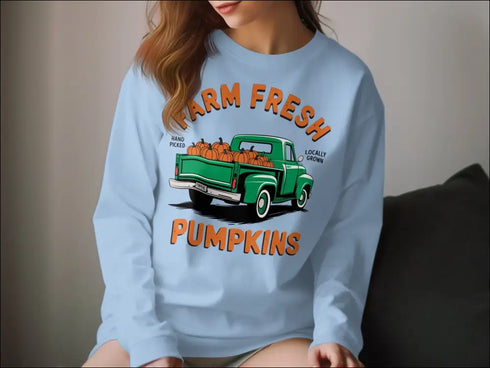 Light blue sweatshirt featuring a green truck and hand-picked farm fresh pumpkins design
