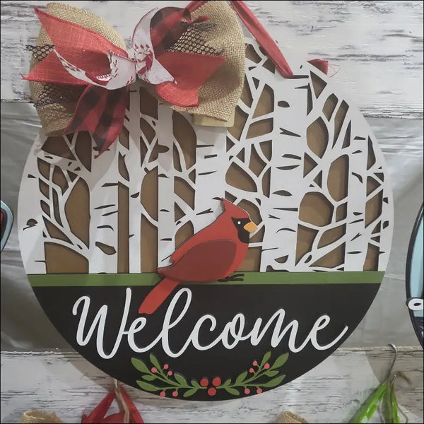 Round door hanger sign featuring handpainted cardinal and birch trees with rustic wooden wreath