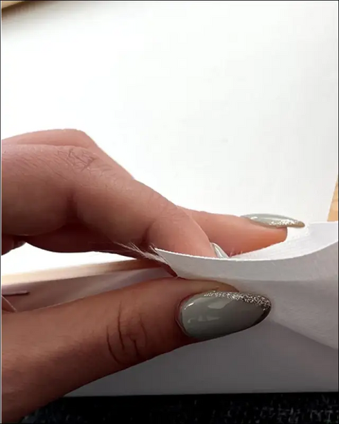 Soft white textured fabric held by fingers on one year anniversary canvas print