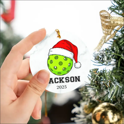 Lime green golf ball Christmas ornament with Santa hat design on high-quality white ceramic background