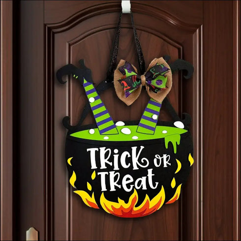 Halloween cauldron door decoration featuring a handpainted wood treat door hanger sign