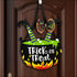 Halloween cauldron door decoration featuring a handpainted wood treat door hanger sign