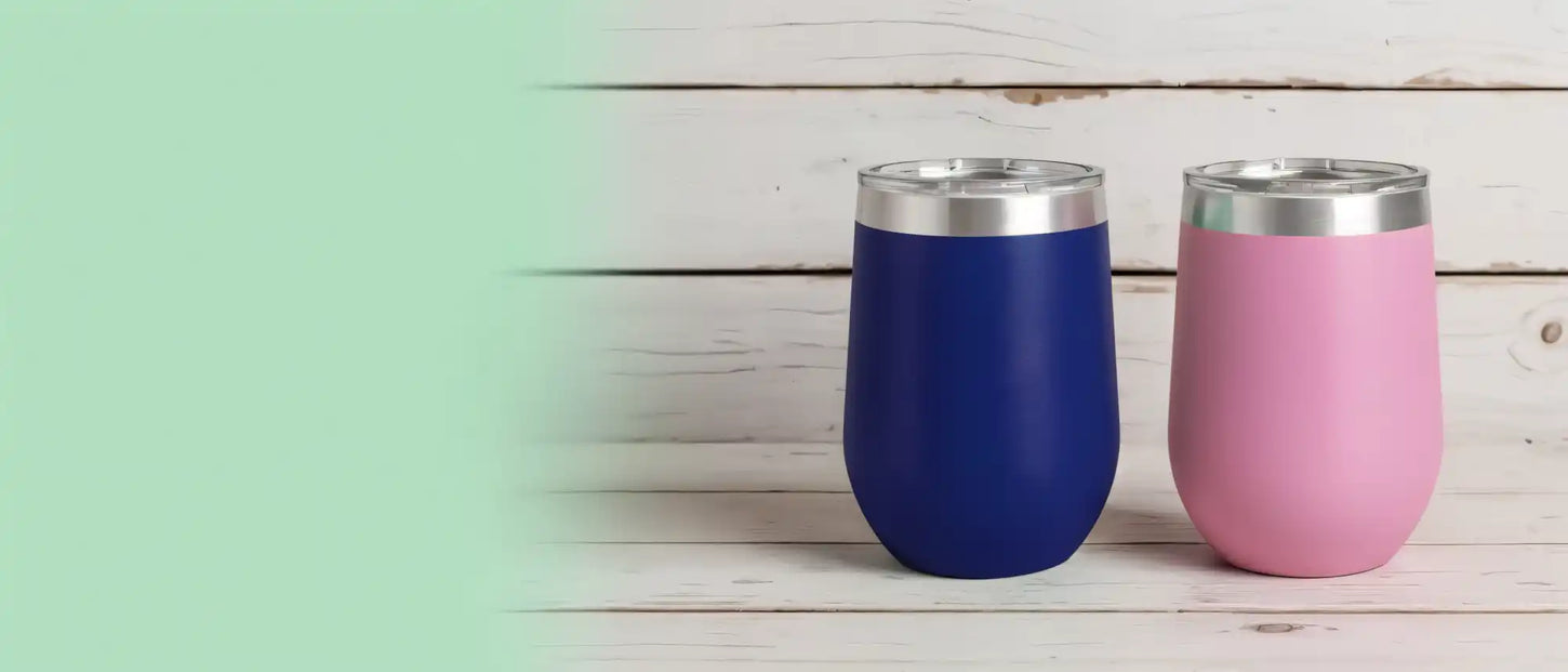 Two stemless wine tumblers, one blue and one pink, with silver rims and clear lids.