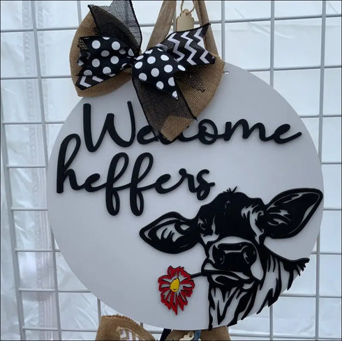 Round Welcome Heifers Door Hanger sign featuring a cow and bow, ideal farmhouse decor