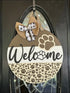 Round wood door hanger sign featuring a paw print design for dog lovers
